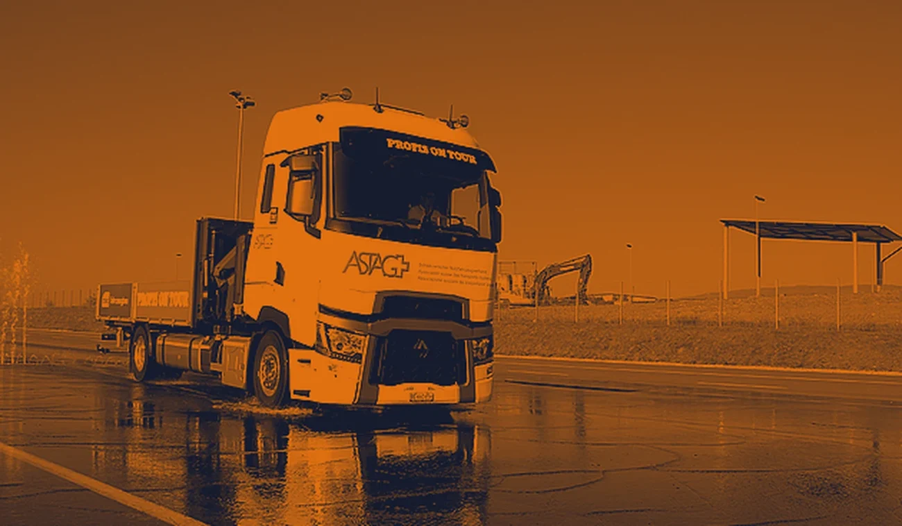 Camion ASTAG lors d'un exercice de conduite sur piste mouillée, traitement graphique duoton orange